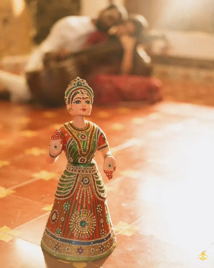 Abhijith & Chinnu: painted terracotta doll on a patterned tile floor, a detail from the wedding home