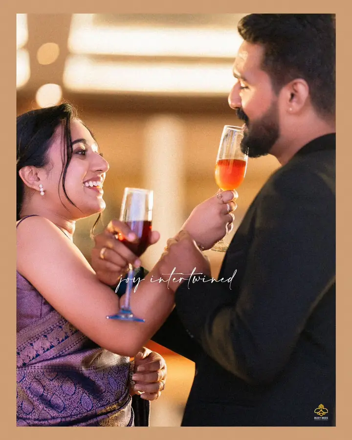 Couple share a toast with arms linked at the reception