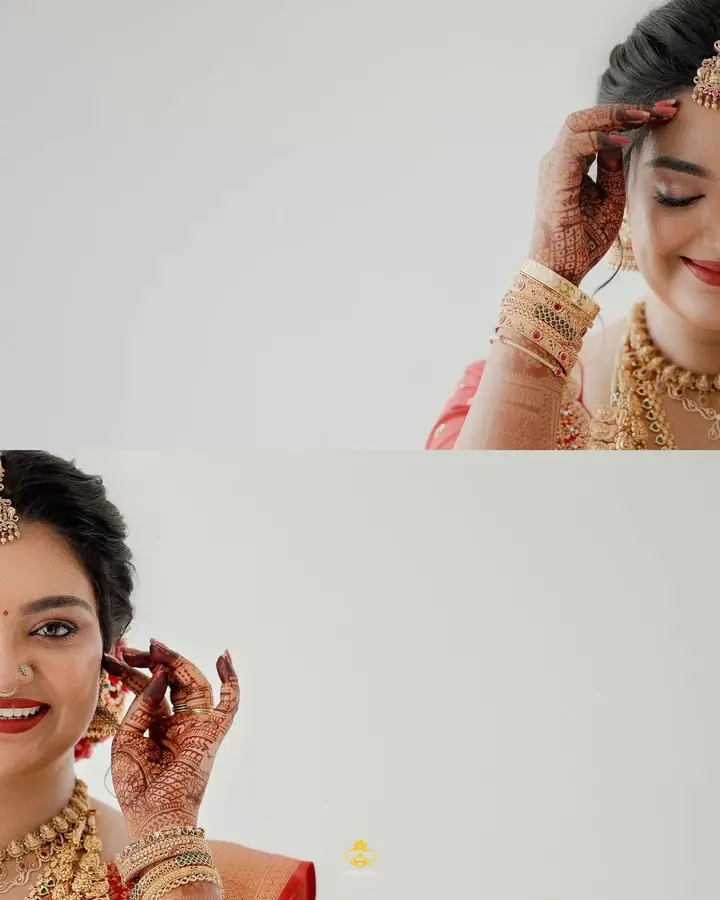 The bride adjusts her earring, henna across her hands and gold at her neck