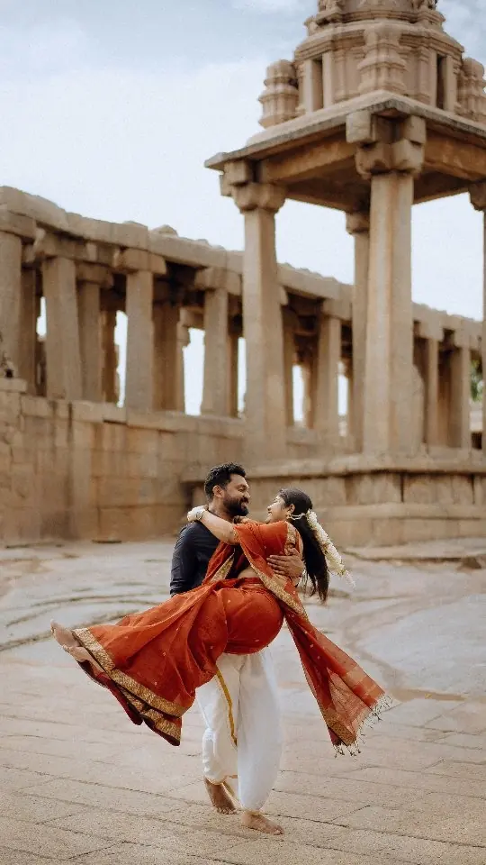 Groom spins the bride across the stone floor of a temple ruin