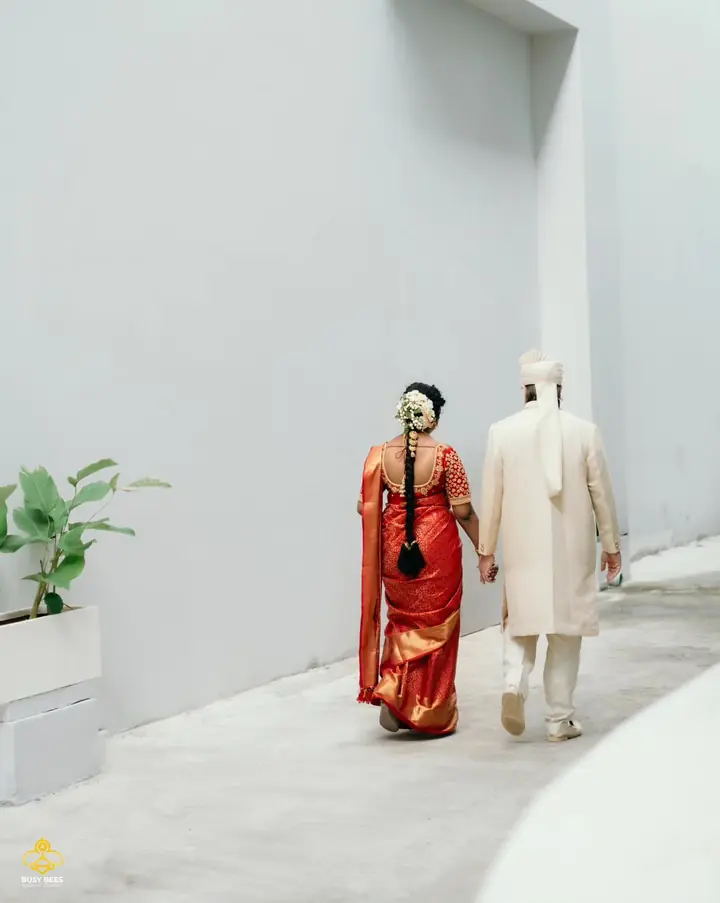 Bride and groom walk away down a sunlit white corridor